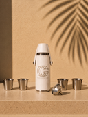 Crossover Golf Pour Four Flask Set with white vegan leather flask, four stainless steel shot glasses, and filling funnel on travertine stone. Golf flask set. Mini flask set. Luxury flask set. Chic flask set
